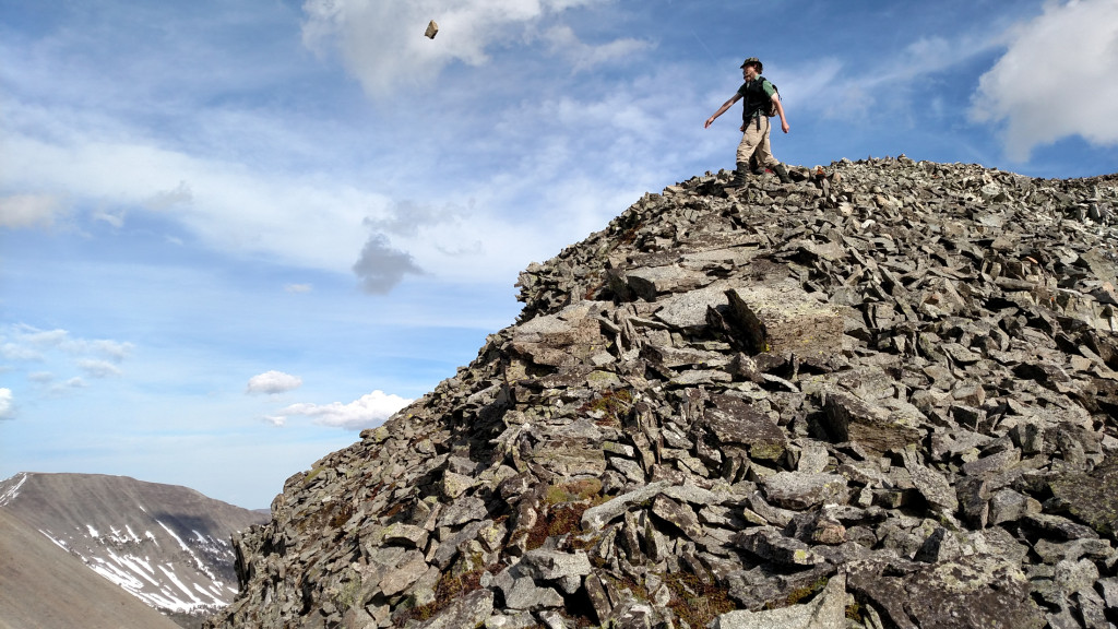 Christian lobbing a rock over the edge.