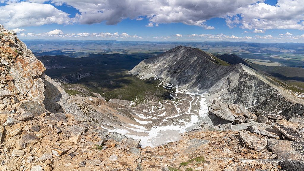 Peering over the edge of The Crater. The ridge following the rim of the Crater will lead you straight to the summit of Deer Lodge Mountain which is far in the distance.